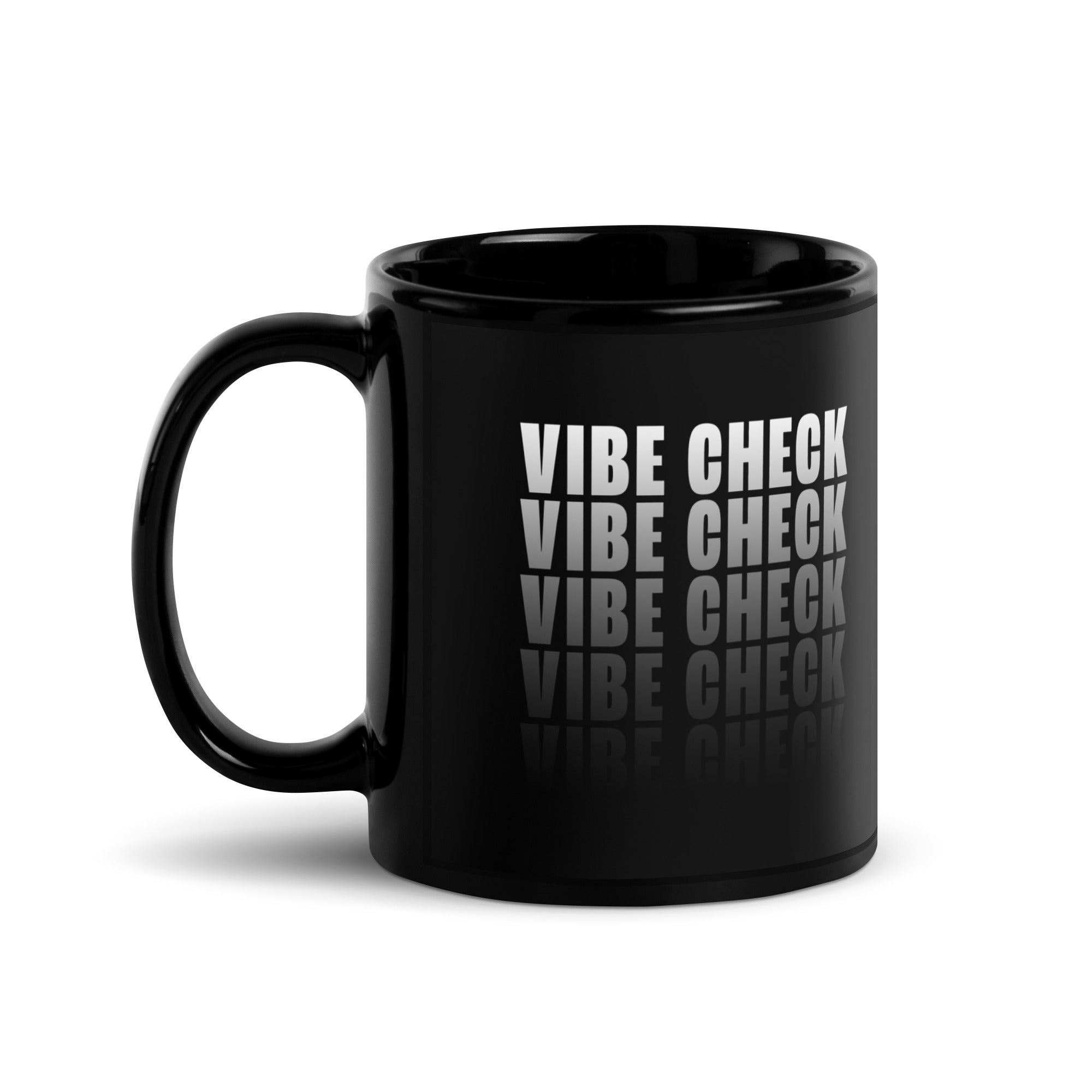 A black glossy coffee mug shown from the side with the handle on the left. The 'VIBE CHECK' design is partially visible, curving slightly around the mug’s surface.