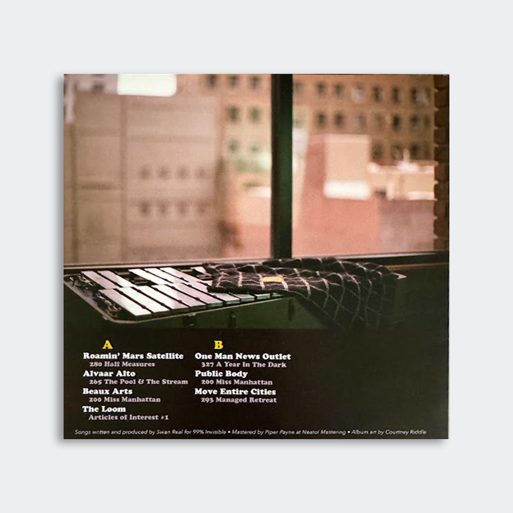 Back cover of a vinyl album featuring an out of focus photo of a cityscape and white text listing the track titles of sides A and B.