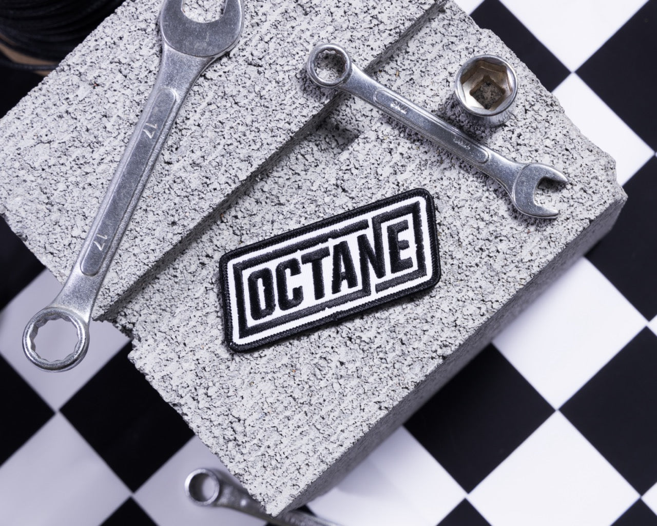 OCTANE' patch on a textured surface with a black and white checkerboard background.