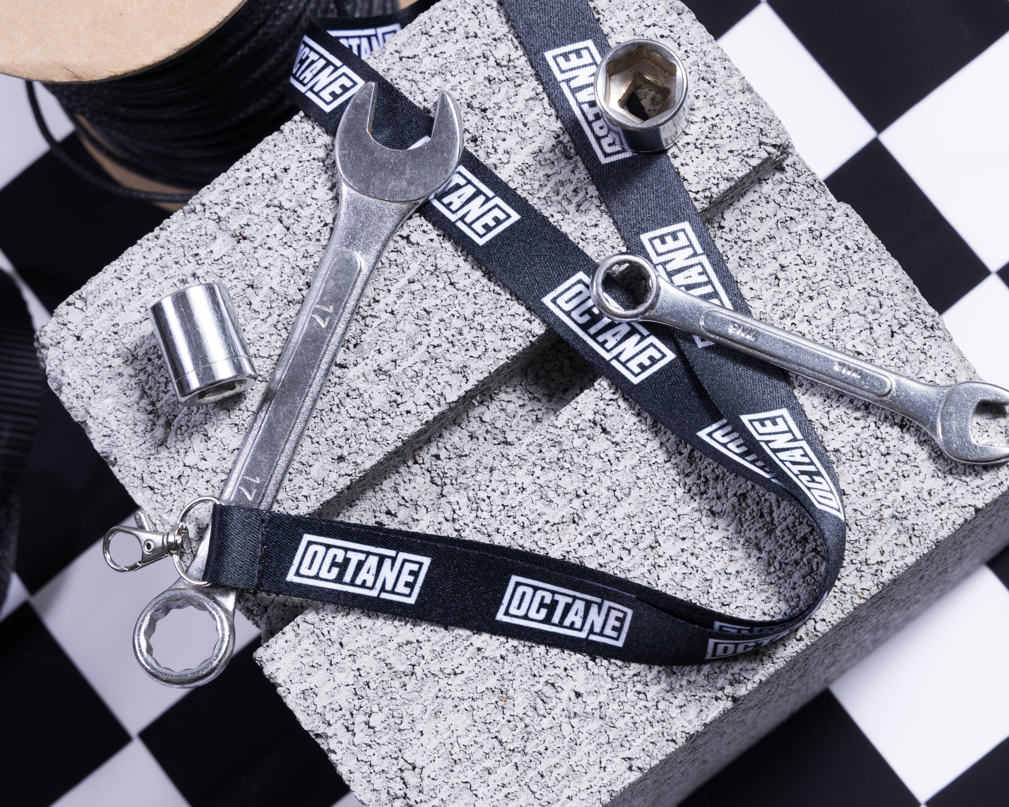 Black lanyard featuring repeated white 'OCTANE' logos, with a metal clip attachment.