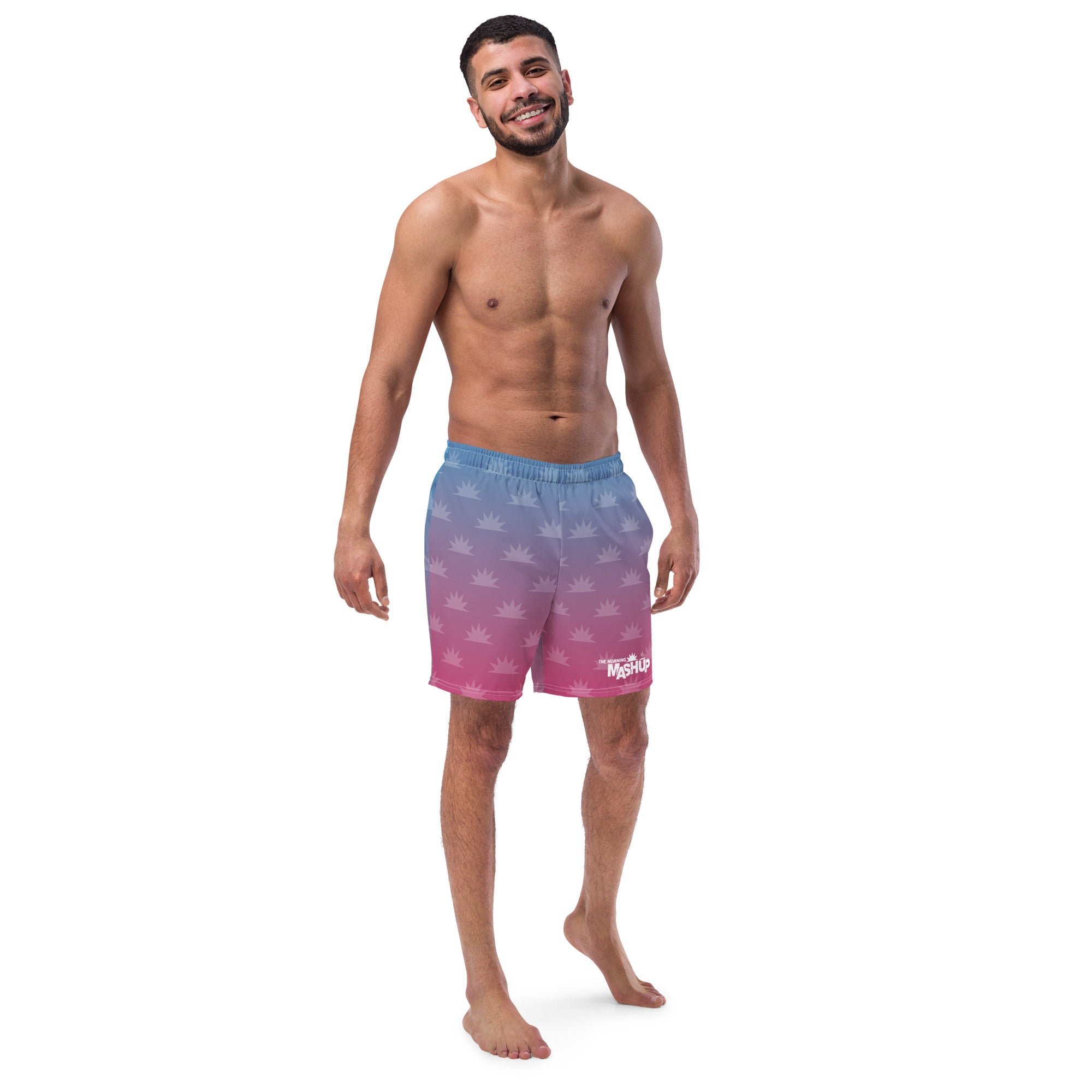 Men's swim trunks with a gradient blue to pink color scheme and a pattern of white crown-like shapes, featuring 'THE MORNING MASHUP' logo on the bottom right.