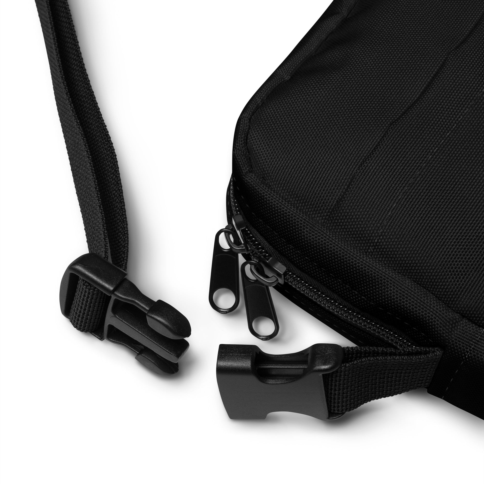 A detailed shot of the bag’s dual-zipper closure and adjustable buckle strap, highlighting its durable black fabric and practical design.