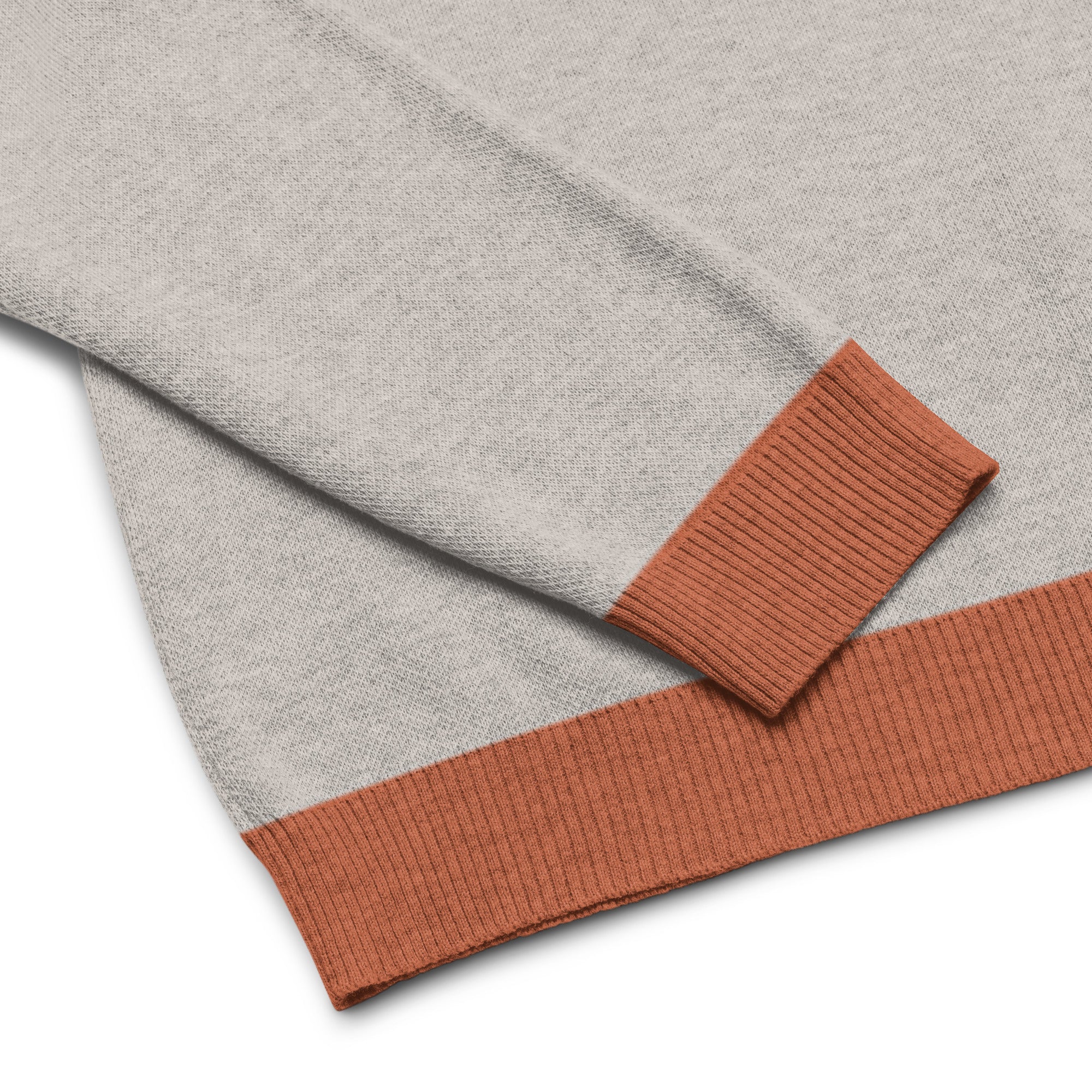 Sand colored sweater with orange ribbed cuffs and hem.