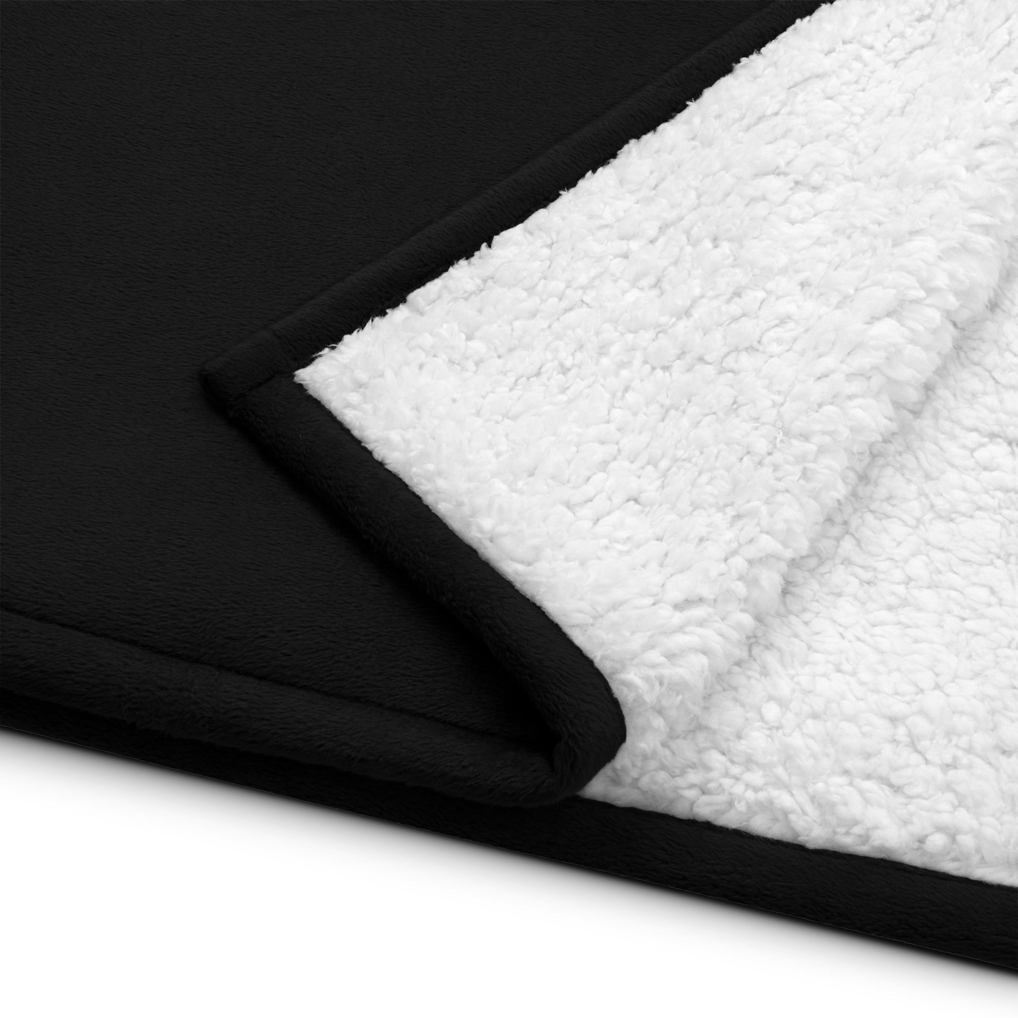 Black and white plush blanket with a soft, fluffy inner lining and smooth exterior.