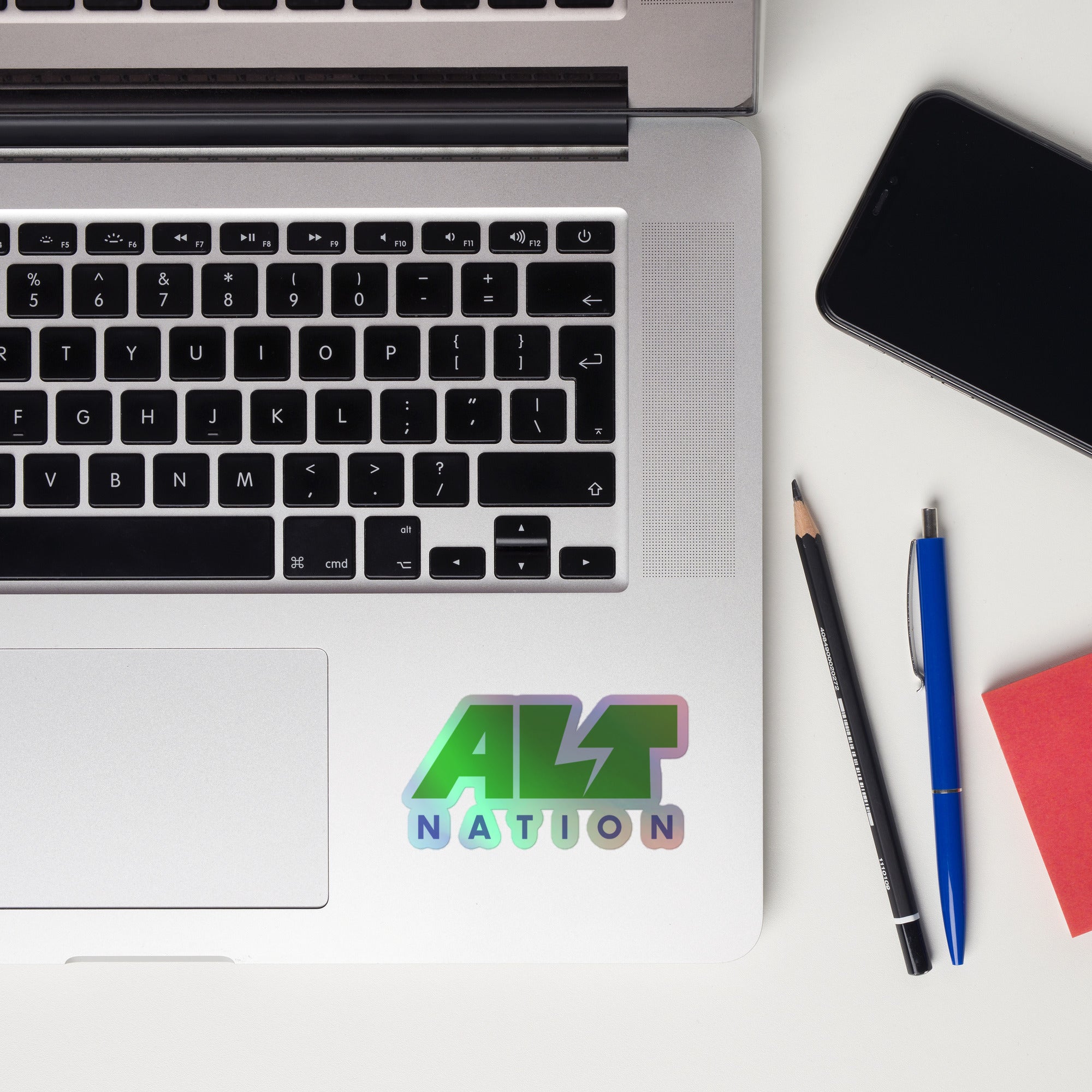 A laptop keyboard displaying a colorful 'ALT NATION' holographic sticker.