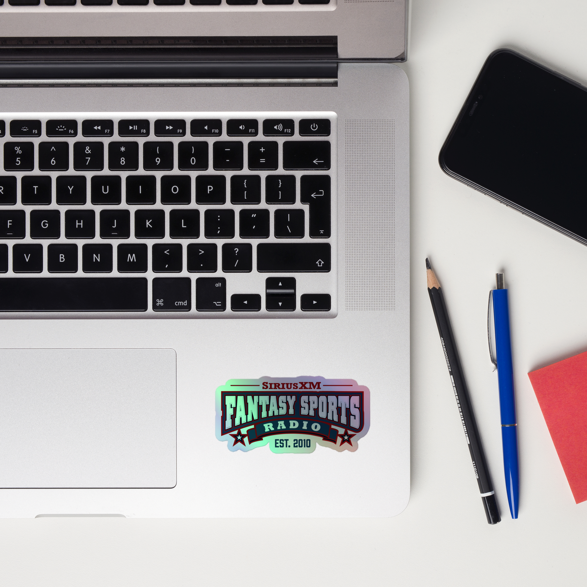 Close-up of a laptop keyboard displaying a 'SiriusXM Fantasy Sports Radio' holographic sticker.