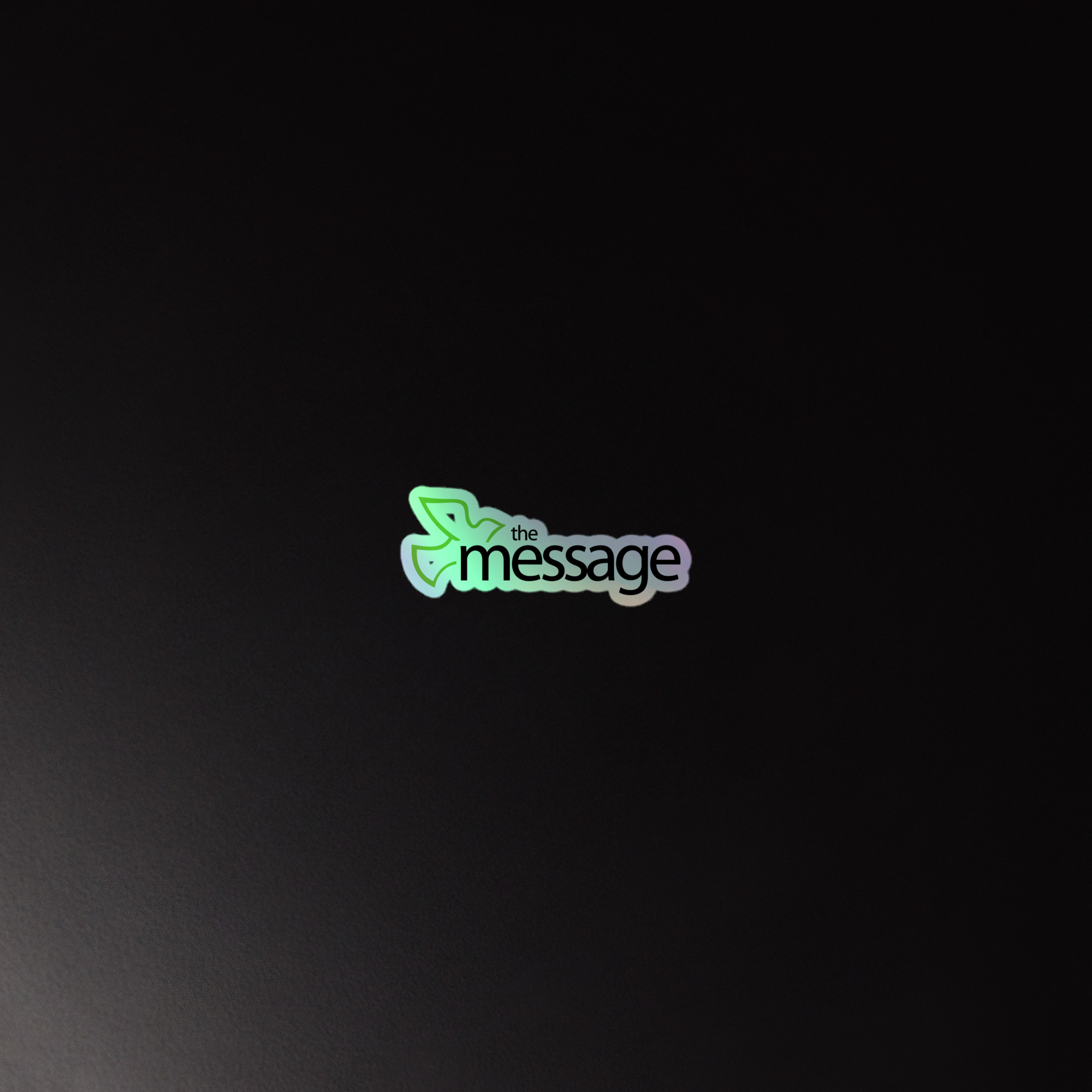 Holographic sticker of 'the message' logo, featuring a leaf design, against a dark background.