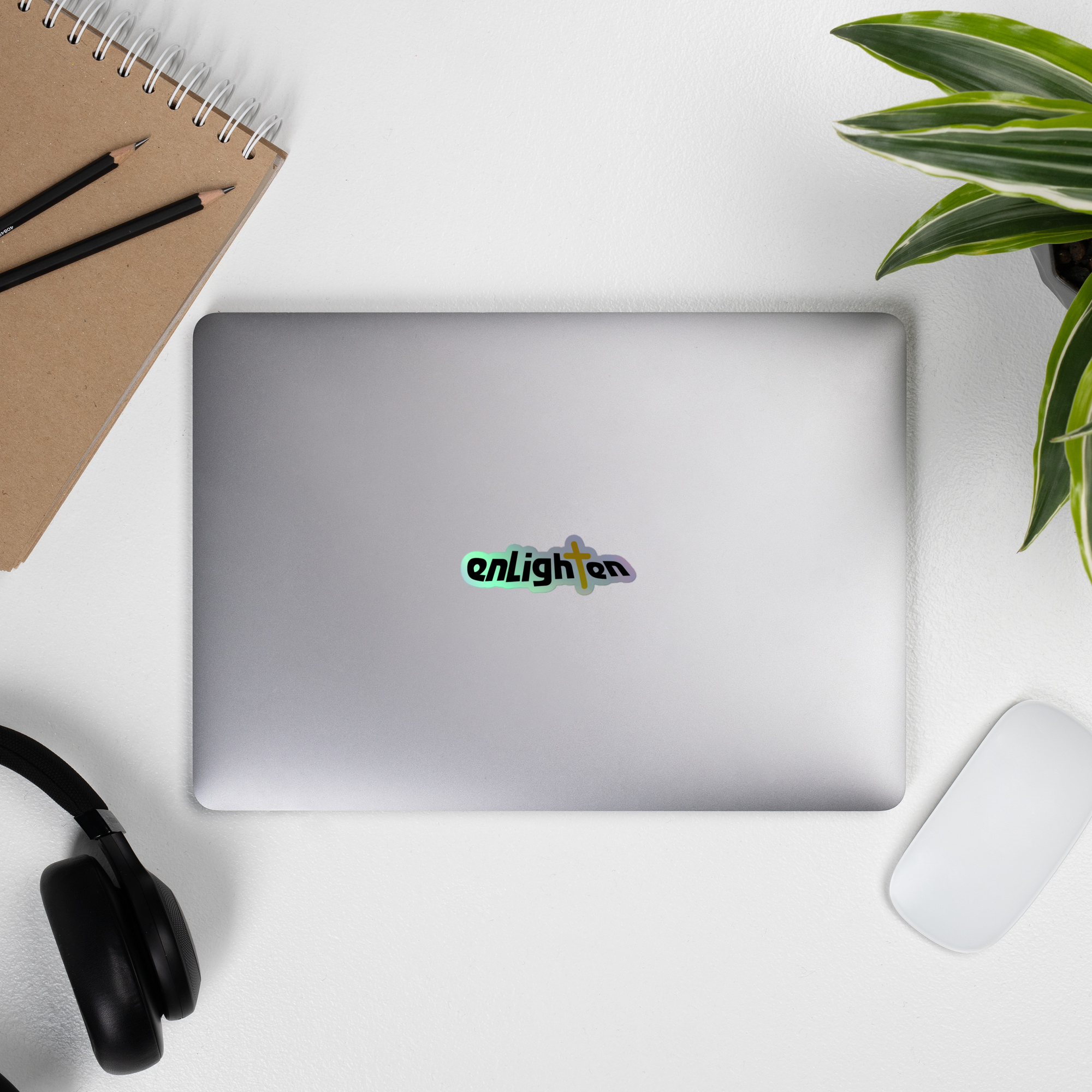 A silver laptop displaying a colorful 'Enlightened' holographic sticker.