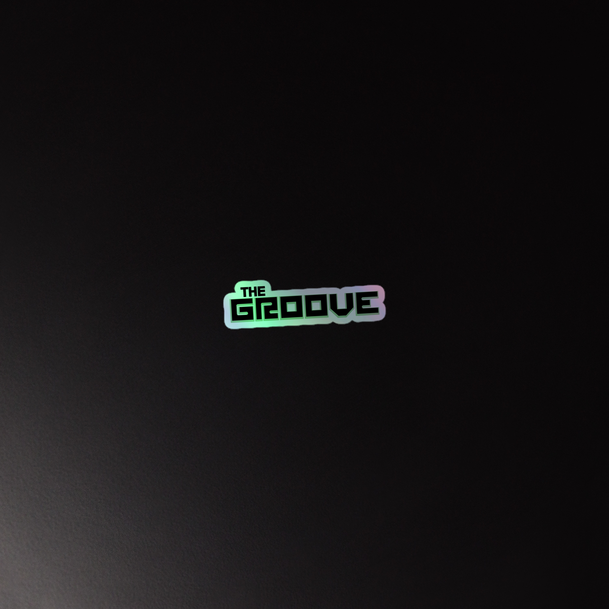 A reflective, holographic sticker that says 'THE GROOVE' against a dark background.