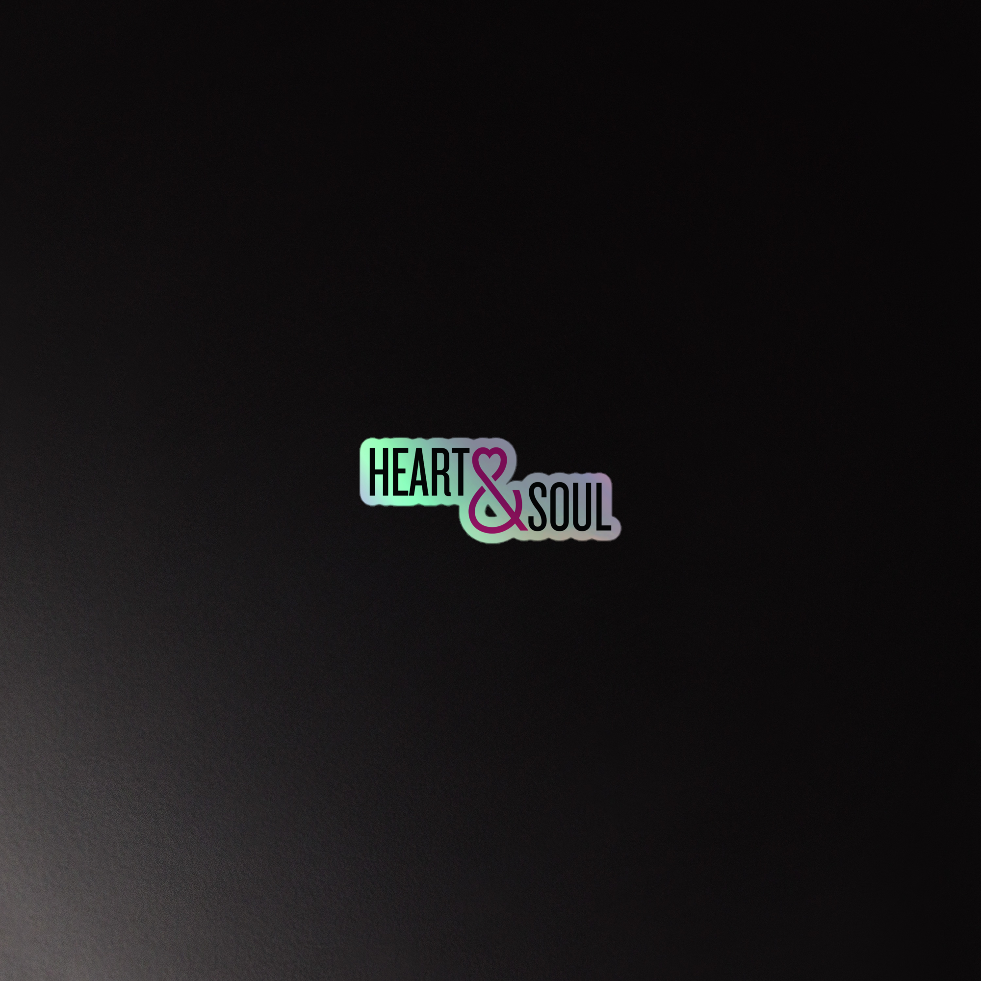 Holographic sticker of the 'HEART & SOUL' logo in colorful typography on a dark background.