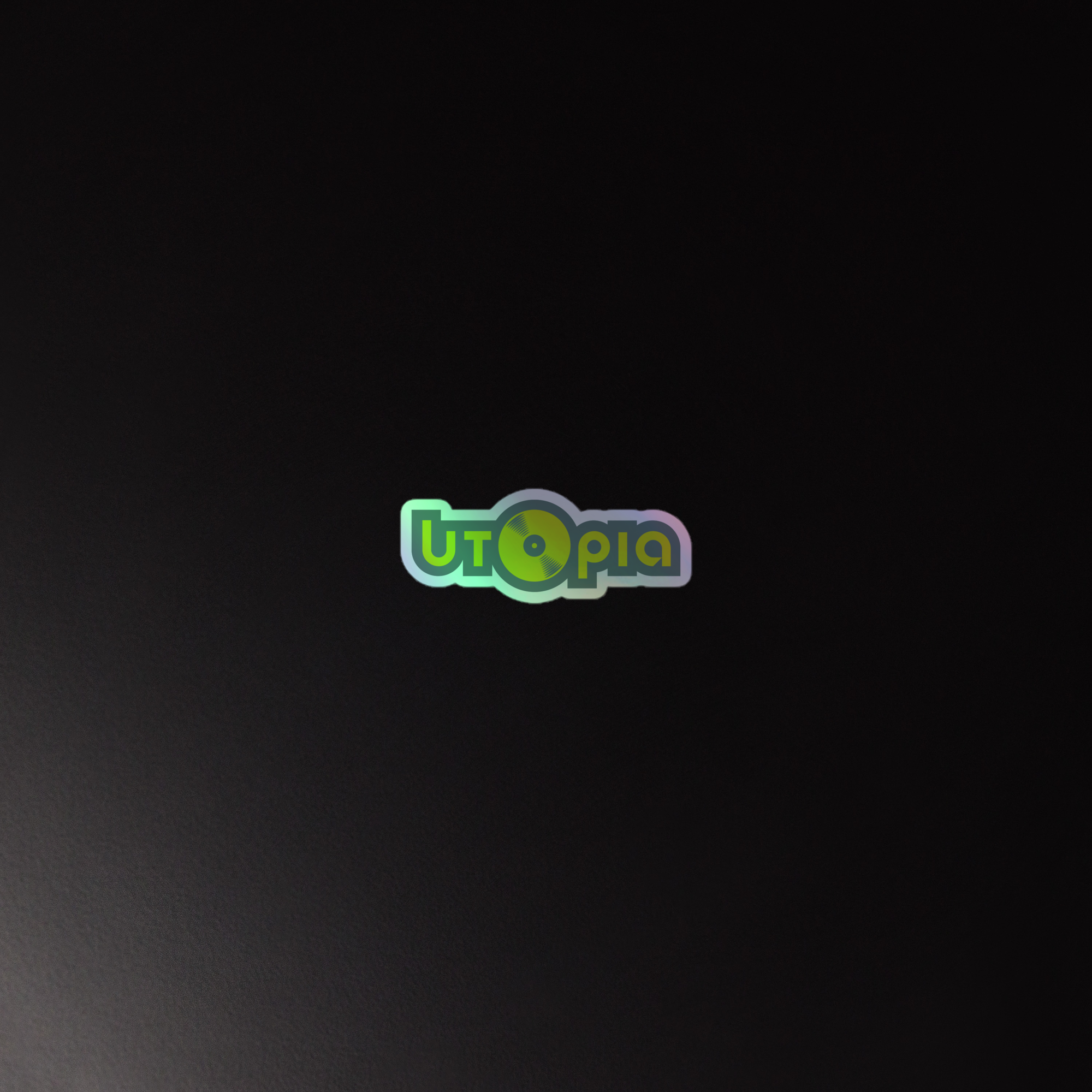 A reflective, holographic sticker that says 'Utopia' against a dark background.