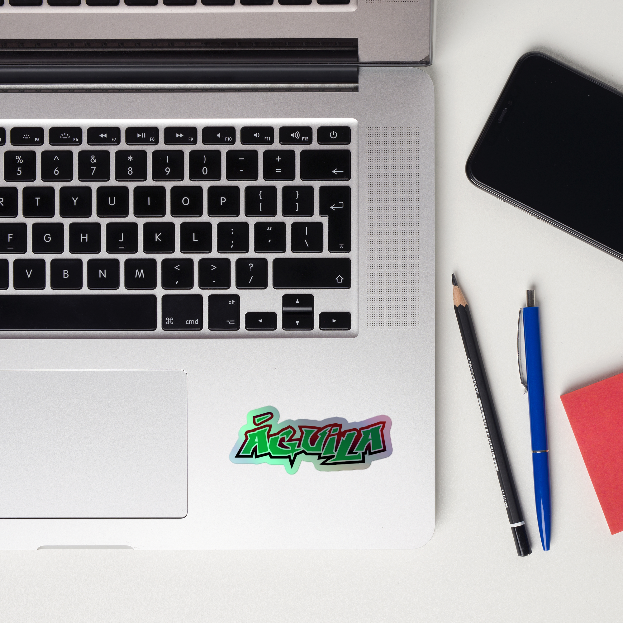 Laptop keyboard displaying a colorful 'Águila' holographic sticker.