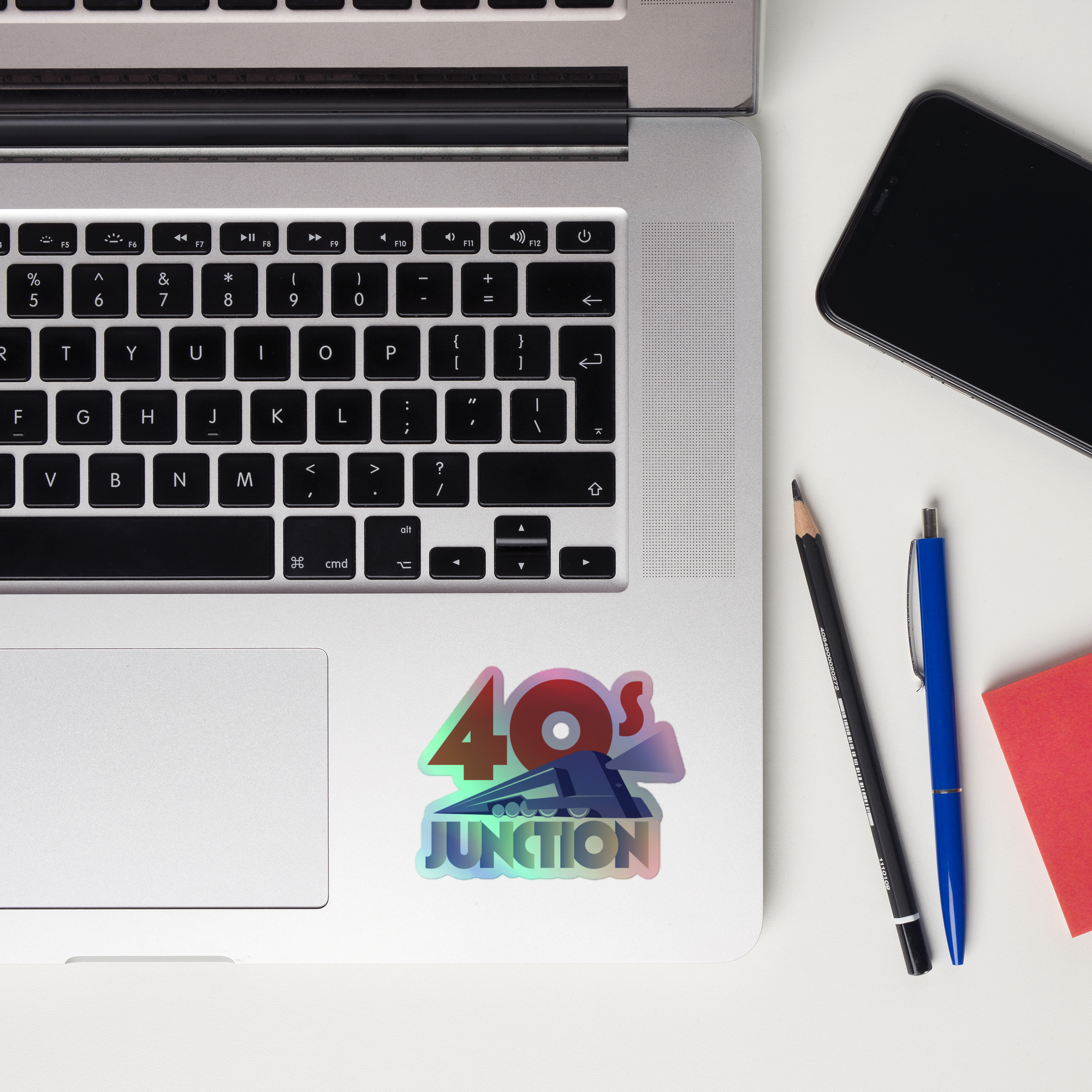 A laptop keyboard displaying the '40's Junction' holographic sticker.