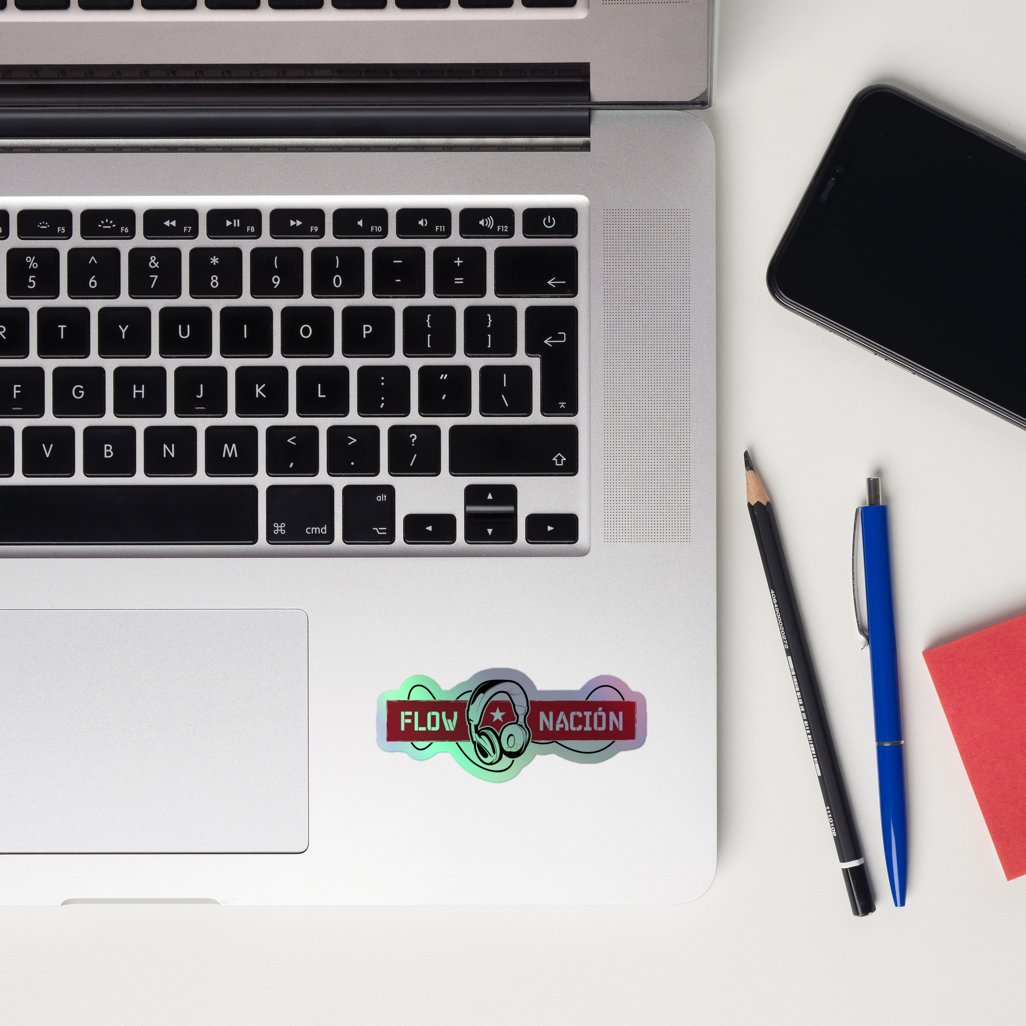 A laptop keyboard displaying a colorful 'FLOW NACIÓN' holographic sticker.