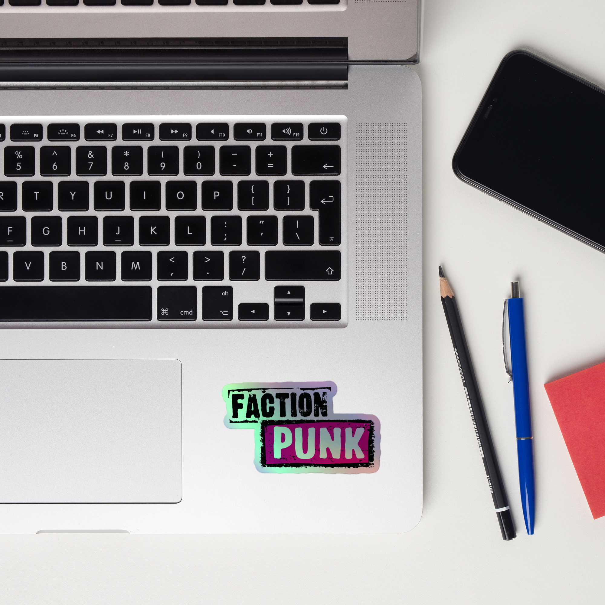 Laptop keyboard displaying colorful 'FACTION PUNK' holographic sticker.