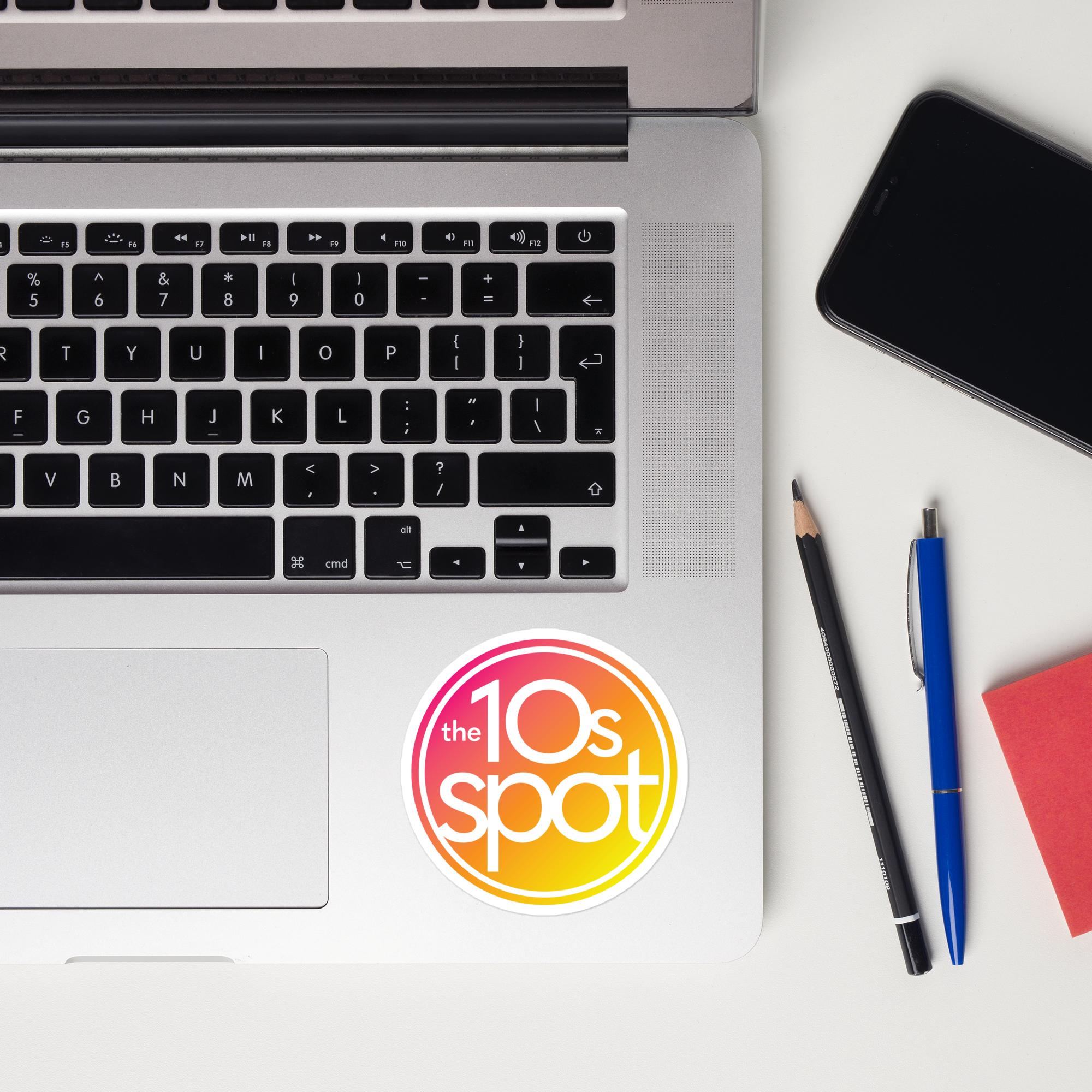 Top-down view of a laptop keyboard displaying a 'the 10s spot' sticker.