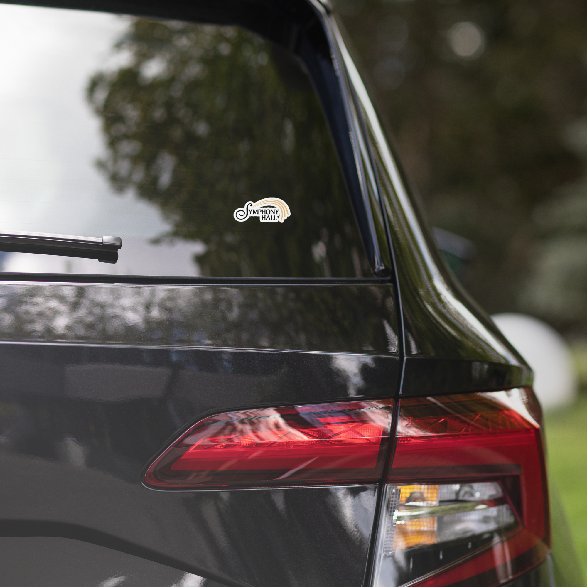 Close-up of a car's rear window displaying a 'Symphony Hall' sticker.