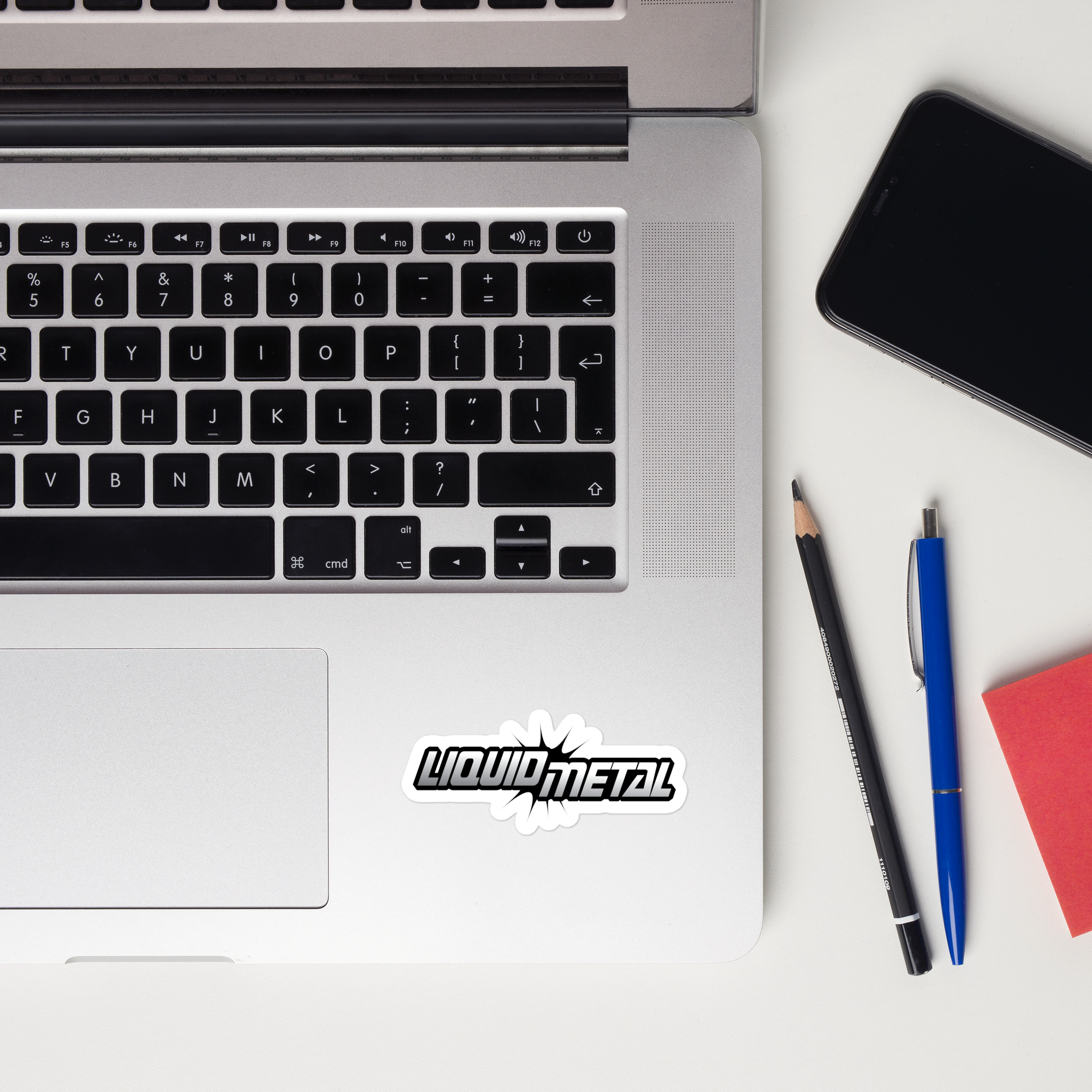 A laptop keyboard displaying a 'Liquid Metal' sticker.