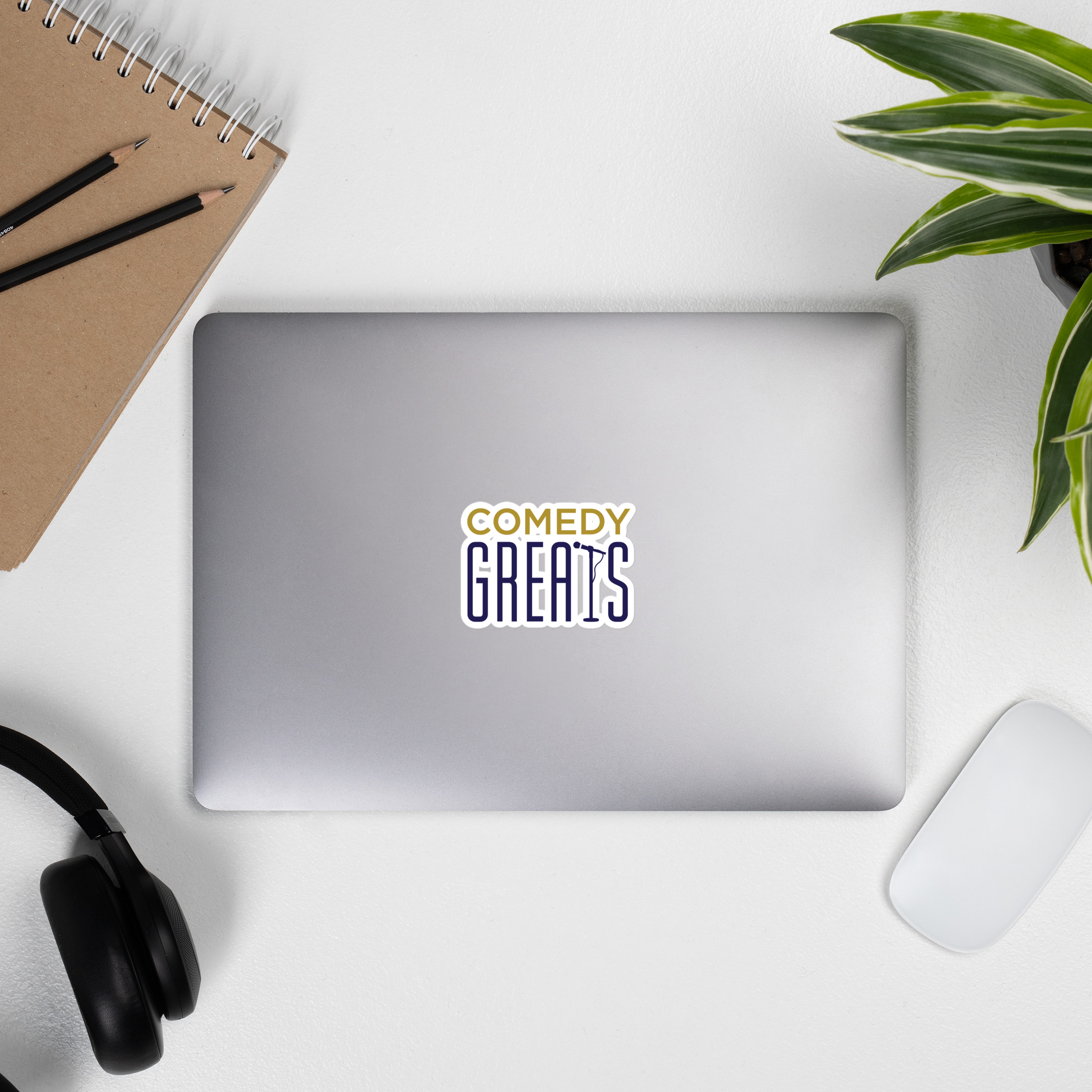 Silver laptop displaying a 'COMEDY GREATS' logo sticker.