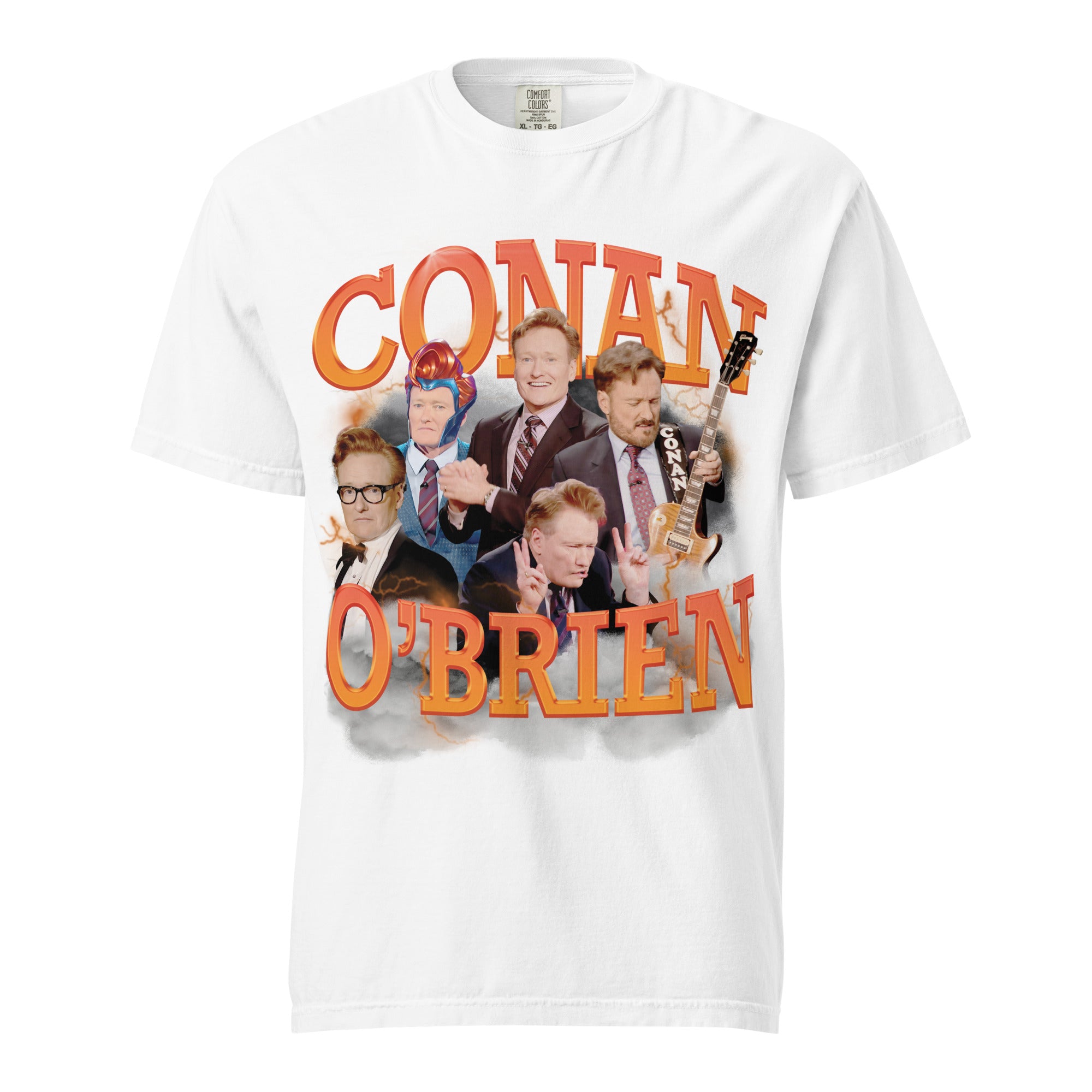 A white t-shirt featuring a graphic design of Conan O'Brien, showcasing multiple images of him in different expressions and outfits, including one with glasses and another playing a guitar. The text 'CONAN O'BRIEN' appears in bold, orange 3D letters with a cloudy and lightning-filled background.