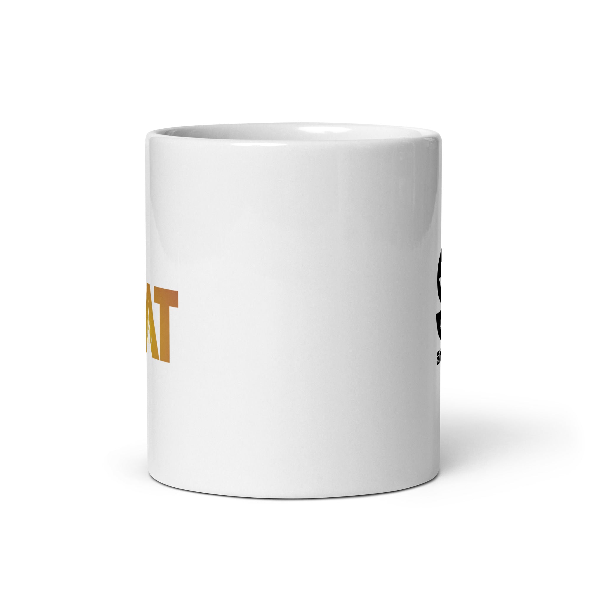 The side of the mug opposite of the handle. It is white mug with barely visible letters in gold on one side and black on the other. Against a white background.