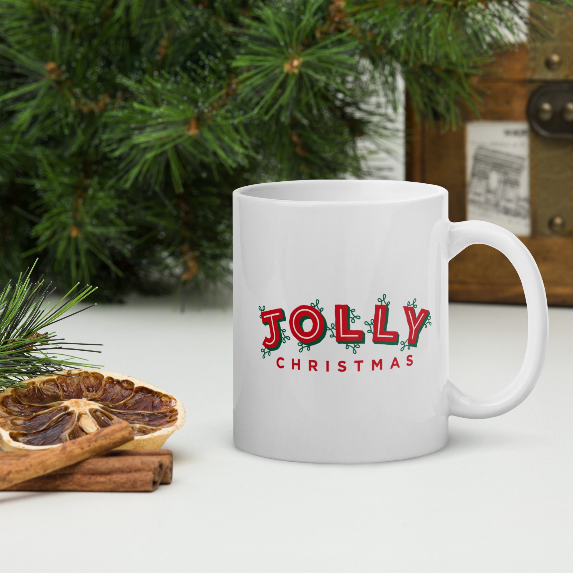 A white mug with 'JOLLY CHRISTMAS' printed in red letters.